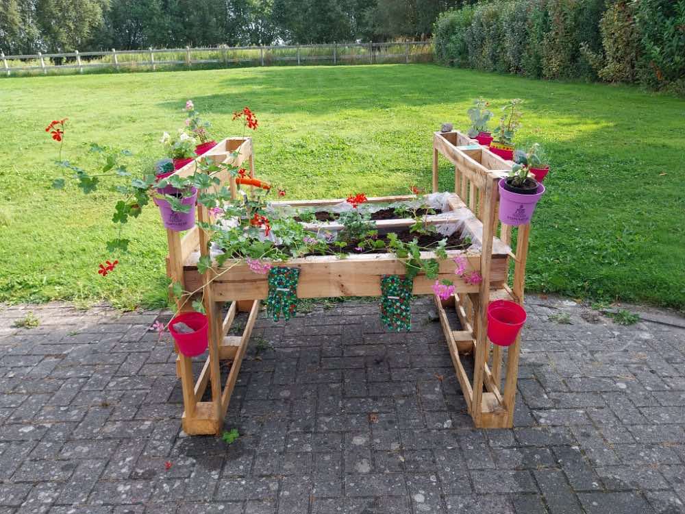 Une jardinière fleurie posée au bord de la grande pelouse