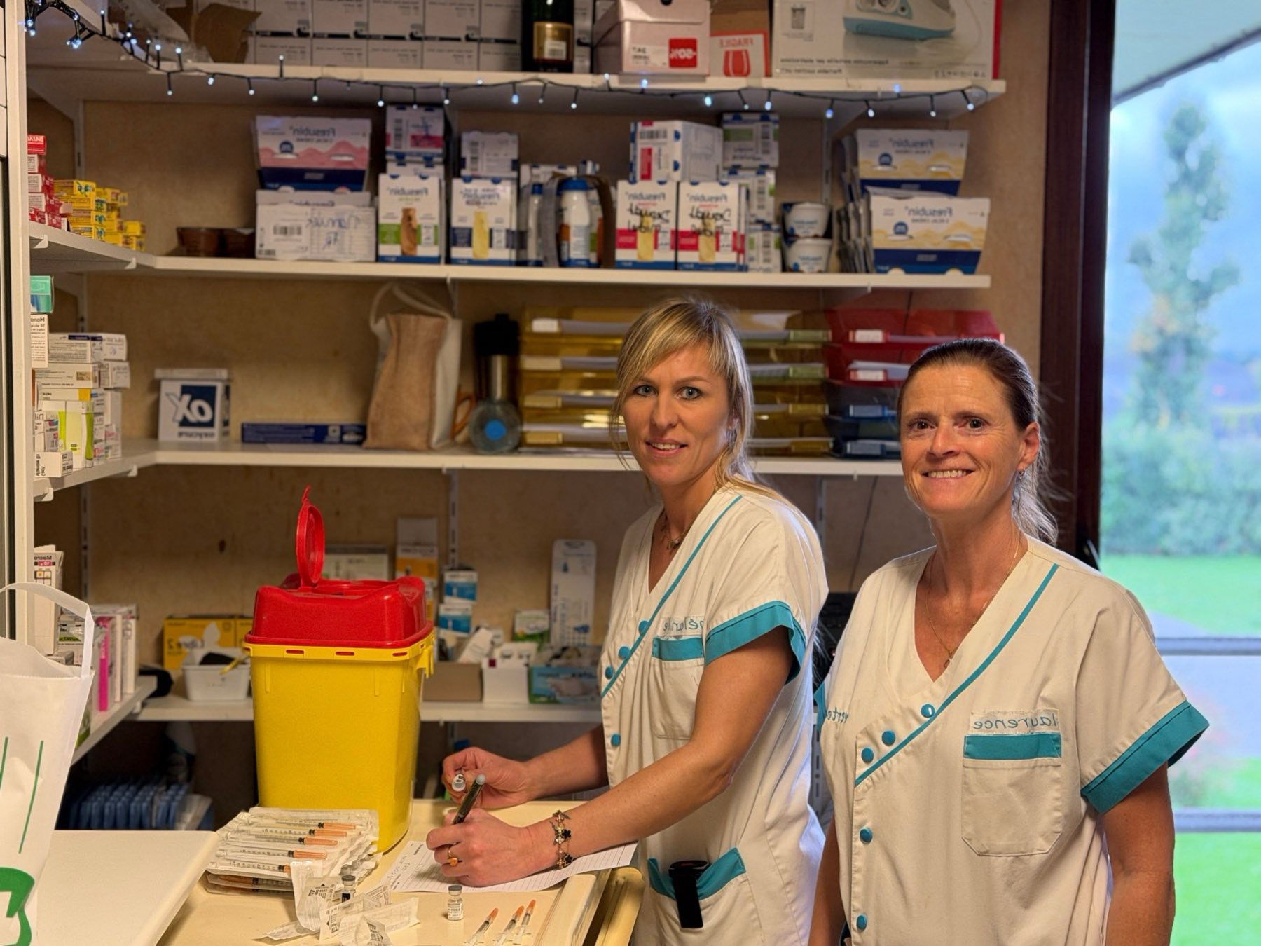 Deux soignantes de l'équipe Verte Fontaine, souriantes, à l'infirmerie de la maison