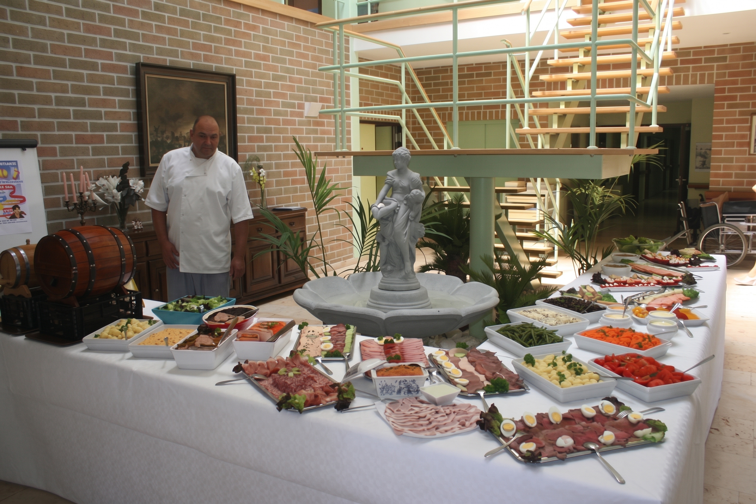 Le chef devant un grand buffet froid dressé dans le hall