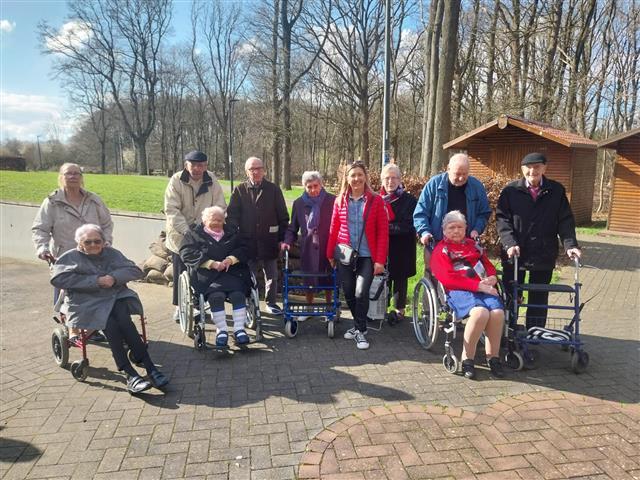 Résidents et accompagnatrice en sortie au parc au printemps